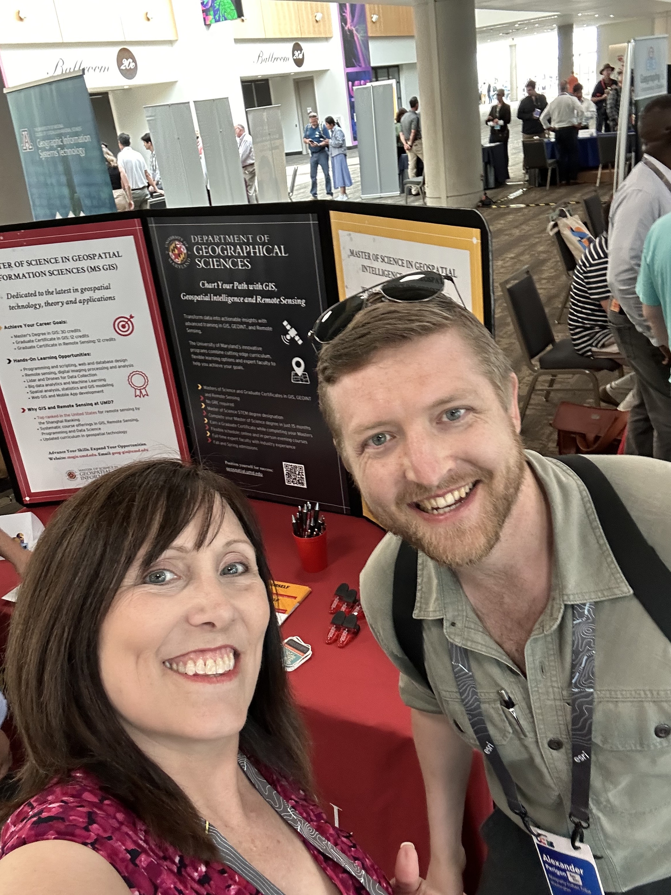 Image 2: Alexander Perigon (Right) and program coordinator Erin Jacobs (Left) at the MS GIS and GEOINT table during the Academic Fair at the Esri User Conference.