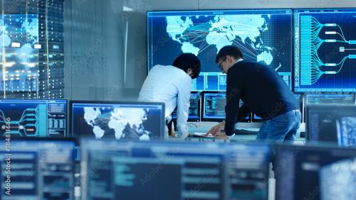 two men collaborating in a control room